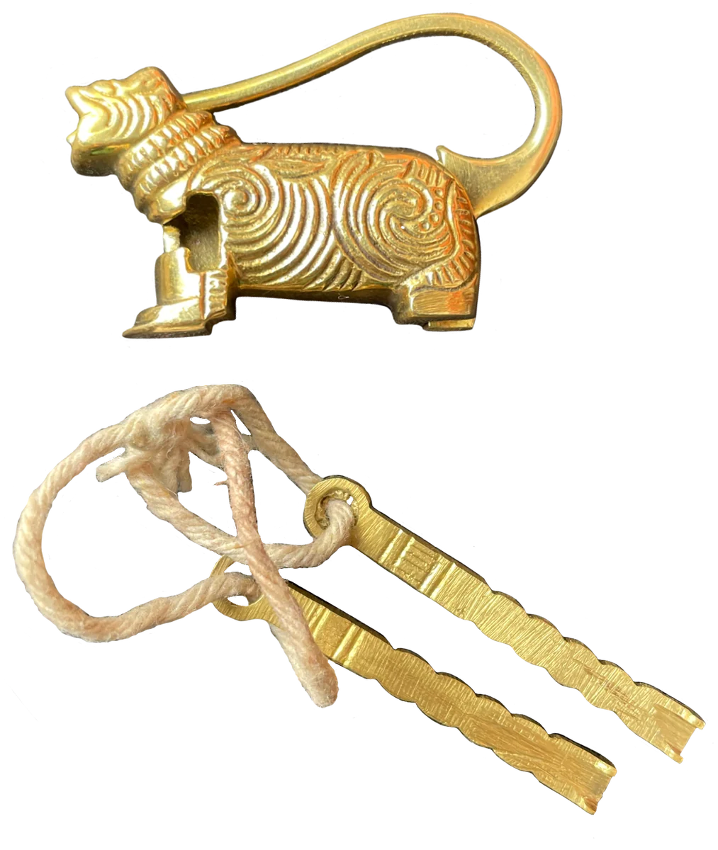 The brass Nepalese padlock in the shape of a tiger, with its two keys on a cotton string